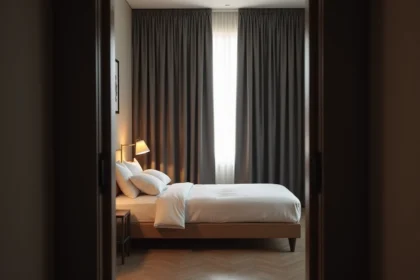 Chambre à coucher avec rideaux occultants gris anthracite tirés, plongeant la pièce dans l'obscurité pour un sommeil optimal